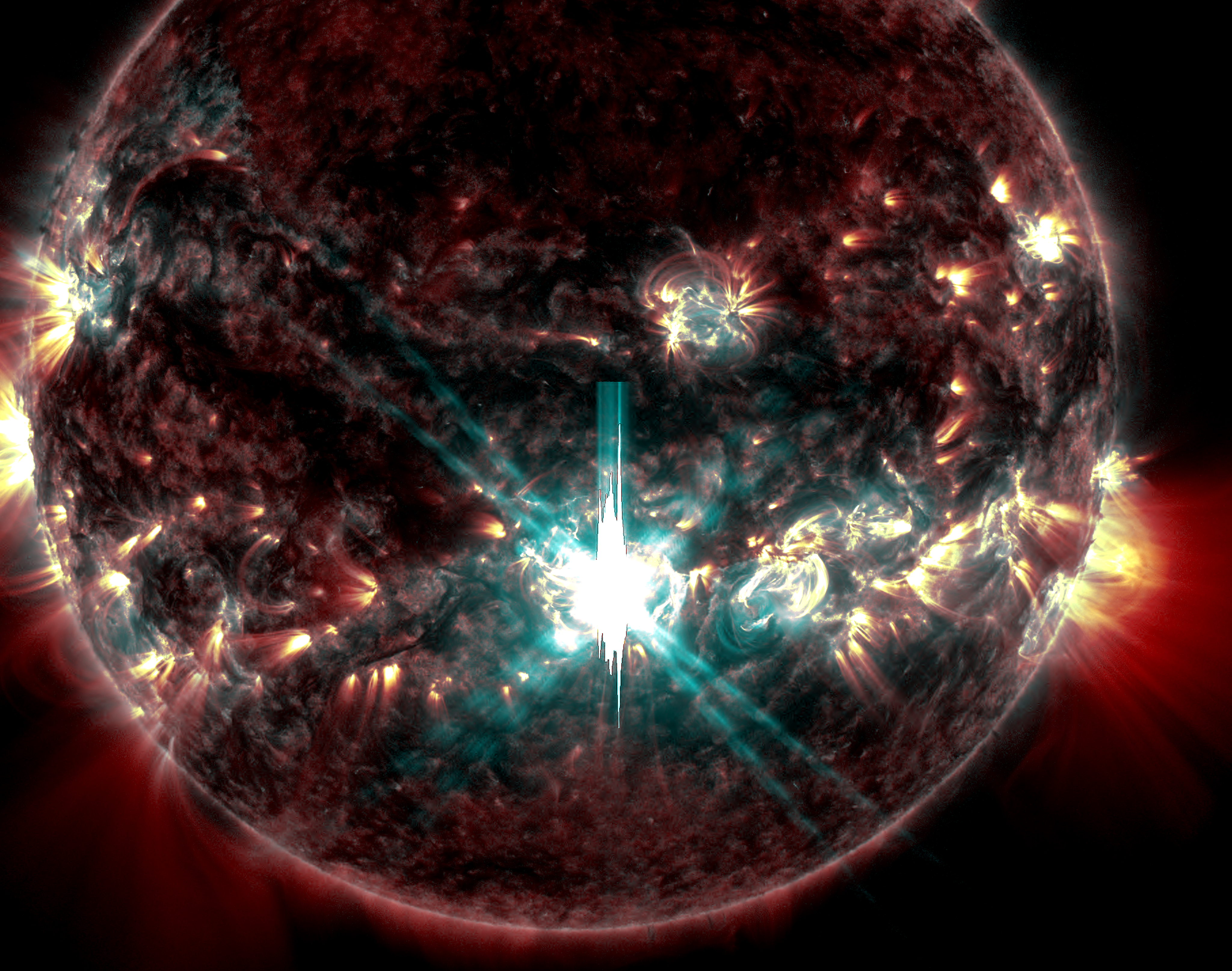 A blue white light shines out of a sunspot on the close up image of the sun while the rest of its surface remains a rusty dark red